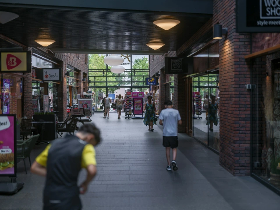 AI monitoring people walk through a covered outdoor shopping arcade.