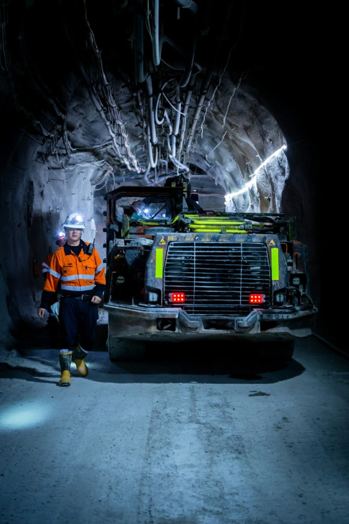 a person standing next to a truck in an underground mine