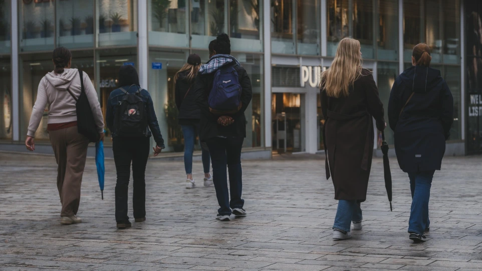 AI monitoring people walk down a city street toward a store.