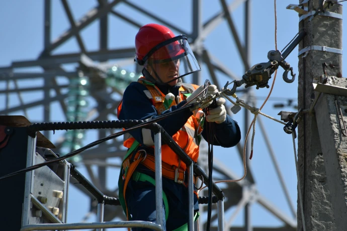 shallow focus photo of man fixing steel cable at a energy plant